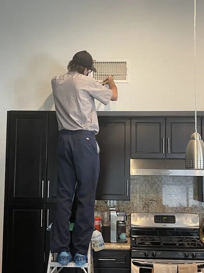 Technician inspecting an air vent during HVAC service in Sapulpa